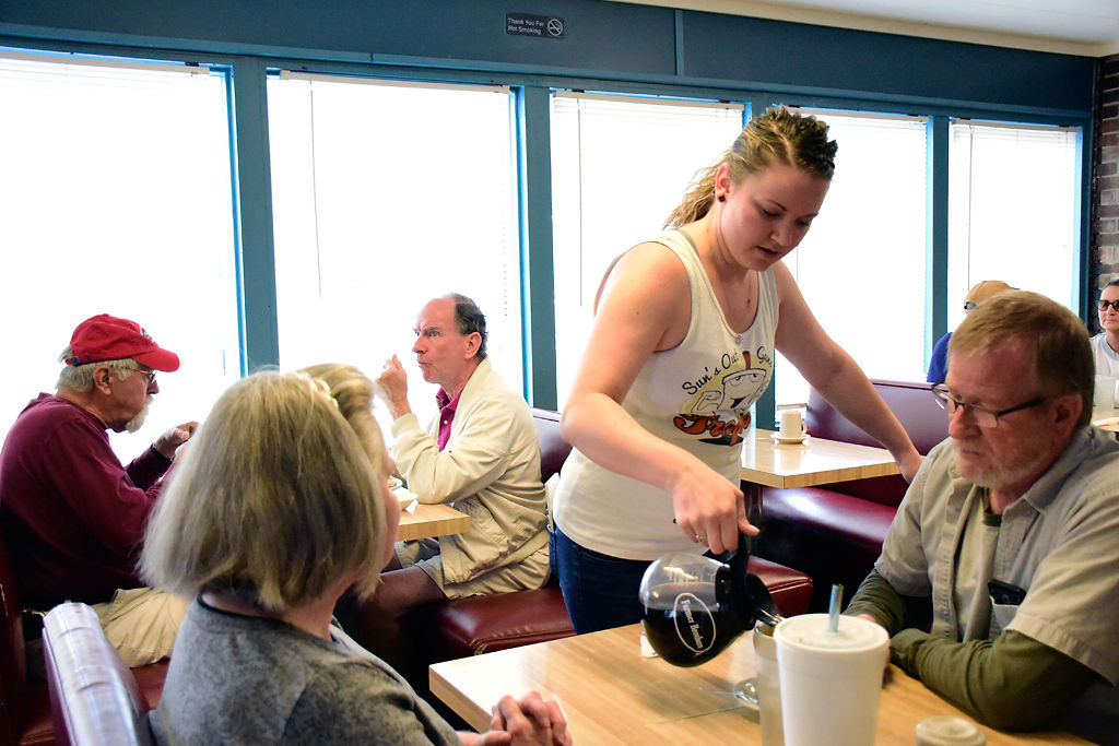 Jennifer Hulen pours coffee for a group of morning customers